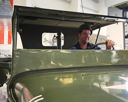 George pretending to drive an Army Jeep